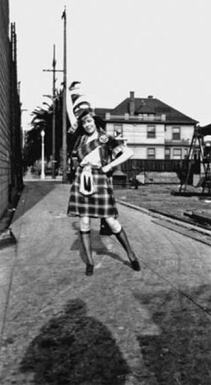 мать, Маргарет Джин Митчелл Уотсон, позирует в шотландском килте с орнаментом клана Маккиннон