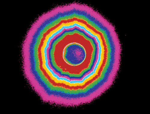 Солнечная корона. Фотография солнечной короны (в синтетических цветах, в центре синее с розовым пятно — Луна), сделанная во время полного солнечного затмения 26 февраля 1998 года. Корона — это внешняя часть солнечной атмосферы, состоящая из разреженного водорода, разогретого до температуры порядка миллиона градусов Цельсия. Изображение «Популярная механика»