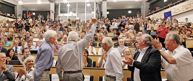 Рис. 1. Физики, собравшиеся на специальном семинаре в ЦЕРНе, аплодисментами встречают сообщение об открытии хиггсовского бозона. Кто знает, куда это открытие физиков заведет