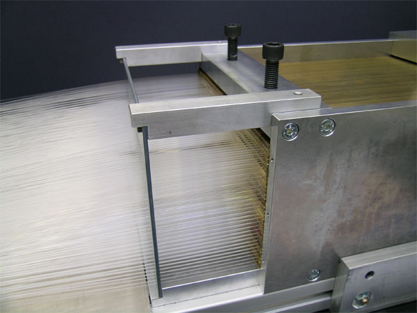 Рис. 3. Кварцевые оптоволокна в процессе укладки в пазы латунной матрицы ZDC. Фото с сайта cdsweb.cern.ch