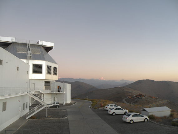 Вид на один из телескопов «Магеллан» (слева) и поселок в обсерватории Лас-Кампанас (справа внизу). Высокая вершина за поселком — гора, где будет расположен 20-метровый телескоп GMT