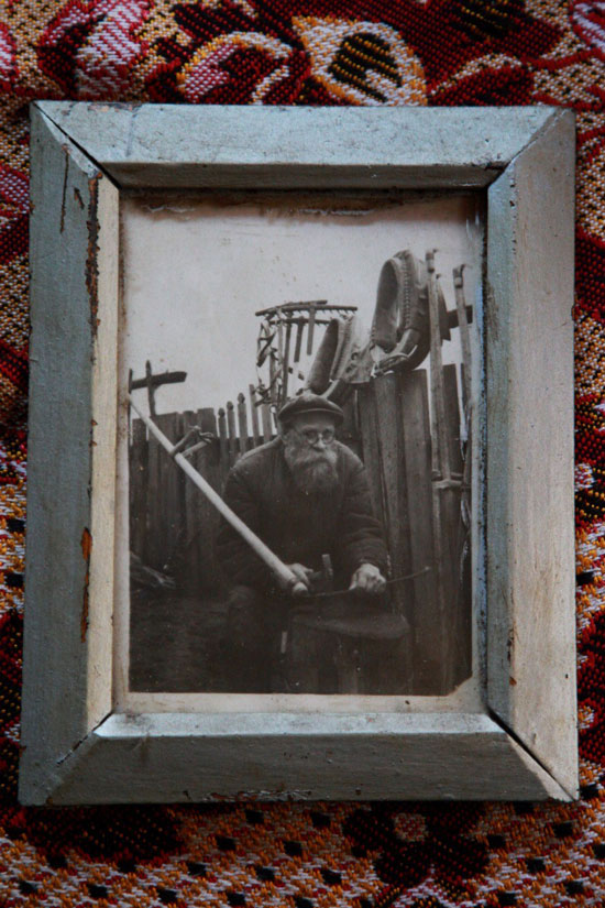 Алексей Михайлович Игнатов чинит косу для колхоза