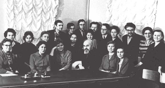 Сектор славянского языкознания, 1961 год (Москва, Трубниковский пер., 30а). \nСидят: М. И. Ермакова, Е. И. Демина, Л. Э. Калнынь, С. Б. Бернштейн, К. И. Ходова, И. К. Бунина. \nЗа ними стоят: Г. П. Клепикова, Р. В. Булатова, Л. С. Малаховская, И. Е. Можаева, Н. Г. Владимирская, Г. П. Нещименко, В. Н. Топоров, Р. М. Цейтлин, Е. В. Чешко. \nВ заднем ряду: А. А. Зализняк, В. М. Иллич-Свитыч, Г. К. Венедиктов, В. А. Дыбо, Л. Н. Смирнов («ТрВ» №1(245), 16.01.2018)
