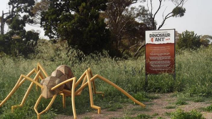 Скульптура муравья-динозавра и инфостенд