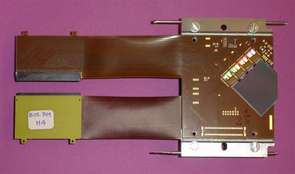 Рис.&nbsp;3. Пластина с полупроводниковым детектором вместе с front-end электроникой, снимающей показания этого детектора. На&nbsp;этой пластине, на обеих ее сторонах, смонтированы сразу два детектора. Фото из статьи Journal of Instrumentation, 3 S08007 (2008)