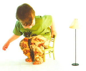 Другое проявление неверного двойственного восприятия — ошибочная оценка размеров, типичная для детей в возрасте от 18 до 30 месяцем, которые часто относятся к уменьшенным копиям предметов точно так же, как к предметам в натуральную величину. Например, этот малыш тщетно пытается усесться на малюсенький стульчик. (В экспериментах используются еще более мелкие предметы.) Фото: «В мире науки»