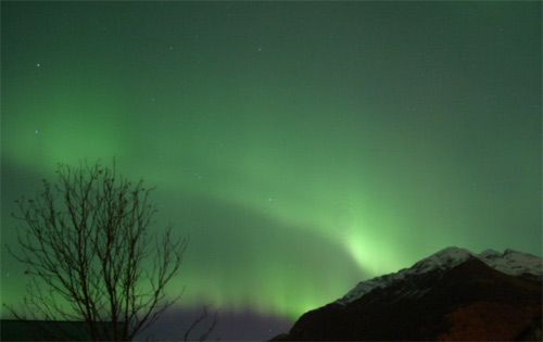 Мощное полярное сияние осветило ночное небо над Аляской в октябре 2003 года. Выброшенные Солнцем заряженные частицы, достигая Земли и сталкиваясь с верхней атмосферой, могут вызвать полярное сияние (фото с сайта valdezlink.com)
