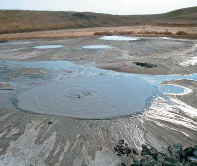 Парадоксы грязевого вулканизма: сопка Ольденбургского, расположенная в пределах Булганакского сопочного поля, представляет собой впадину диаметром около 100 м и глубиной до 4 м. Здесь расположены многочисленные озерца с газирующей илистой водой, а жидкие продукты выброса растекаются по котловине. Керченский п-ов, 2008 г. Фото С. Кох («Наука из первых рук»)