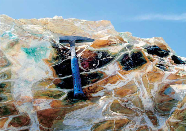 В явлении Хатрурим огонь и вода были неразлучны: роговики (темно-зеленые породы) прошли обжиг при температуре выше 1000°С, а «съедающие» их белые жилы возникли при участии растворов с температурой не более 40°С. Комплекс Даба-Свага, Иордания, 2007 г. Фото Э. Сокол («Наука из первых рук»)