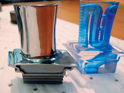 Лопатка газовой турбины и её «напечатанная» прозрачная пластиковая копия, на которой видно расположение каналов охлаждения.