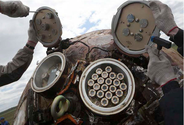 Спускаемый аппарат спутника «Бион-М» после мягкой посадки в оренбургской степи 19 мая 2013 года (предыдущее фото вверху). В выступах расположены объекты, на которых изучали действие открытого космоса. Во время приземления они были защищены от чрезмерного нагрева