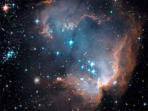 Рис. 6. Скопление молодых звезд NGC 602, родившихся несколько миллионов лет назад на краю соседней галактики Малое Магелланово облако, еще не успев освободиться от материнского газово-пылевого облака, начинает выбрасывать в окружающее пространство собственное вещество, обогащенное новыми химическими элементами. На фото видно, как выброшенный звездами горячий газ взаимодействует с холодным газом облака, раздувая в нем каверну. Это один из бесчисленного множества эпизодов эволюционного цикла космического вещества: Вселенная уже миллиарды лет обогащается элементами, необходимыми для зарождения жизни. Фото с космического телескопа «Хаббл» (NASA). Изображение: «Экология и жизнь»