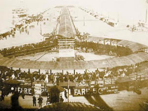 Движущийся тротуар на чикагской Всемирной выставке 1893 года представлял собой крытый навесом конвейер длиной 730 метров с установленными на нём скамейками. Посетители выставки, прибыв по озеру на катерах, переходили с причала на конвейер и со скоростью пешехода ехали к входу на выставку. Изображение: «Наука и жизнь»