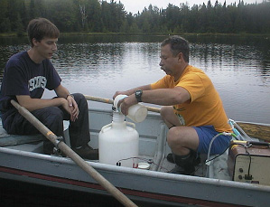 Работа на озере Питер. Исследователи (справа Джонатан Коул — первый автор обсуждаемой работы) готовятся к внесению в озеро NaH13CO3. Фото с сайта Института экосистемных исследований (www.ecostudies.org)