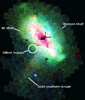 Это изображение Туманности Андромеды из 165 отдельных фрагментов покрывает 40 квадратных градусов неба. Оно составлено по данным обзора галактики, выполненного при помощи широкоугольной камеры телескопа Исаака Ньютона (Isaac Newton Telescope Wide Field Camera, INT WFC). Здесь обобщены данные фотометрии 7 миллионов источников света. Север вверху, восток — слева. Бедные металлами молодые звезды показаны синим цветом, а богатые металлами старые — красным. Стрелками показаны крупные звездные потоки; кружком выделено место, где найден предсказанный компьютерной моделью приливной остаток. Изображение с сайта www.umass.edu