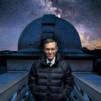 Ави Лёб на фоне купола 15-дюймого телескопа Гарвардской обсерватории