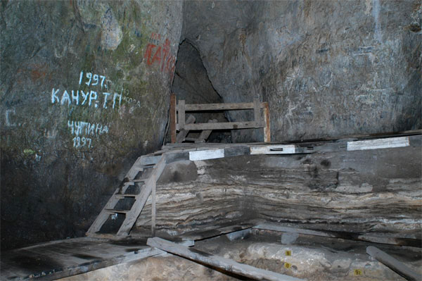 Верхняя часть раскопа в Денисовой пещере. Внизу видны слои 9 и 10. Полосатая толща над ними — голоценовые отложения (последние 10–12 тыс. лет). В это время в пещере стали регулярно жечь костры