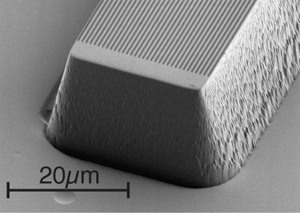 Электронная микрофотография прозрачного бруска из кварцевого стекла с вытравленными на нем периодическими бороздками.