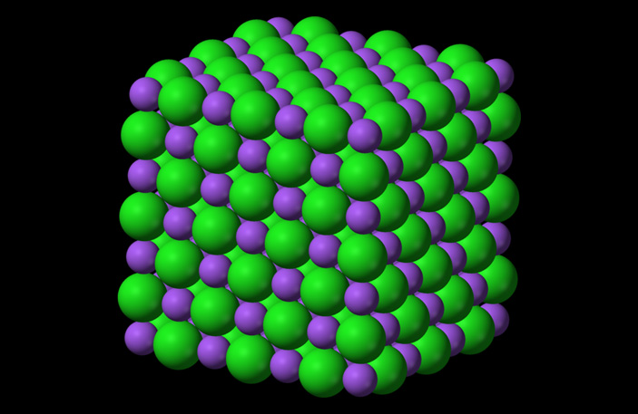 Рис. 3. Структура кристалла поваренной соли NaCl. Зеленые шарики — хлор, фиолетовые — натрий